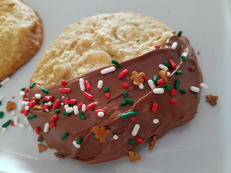 Cookie Natalino com gotas de chocolate branco e nozes banhado com chocolate ao leite