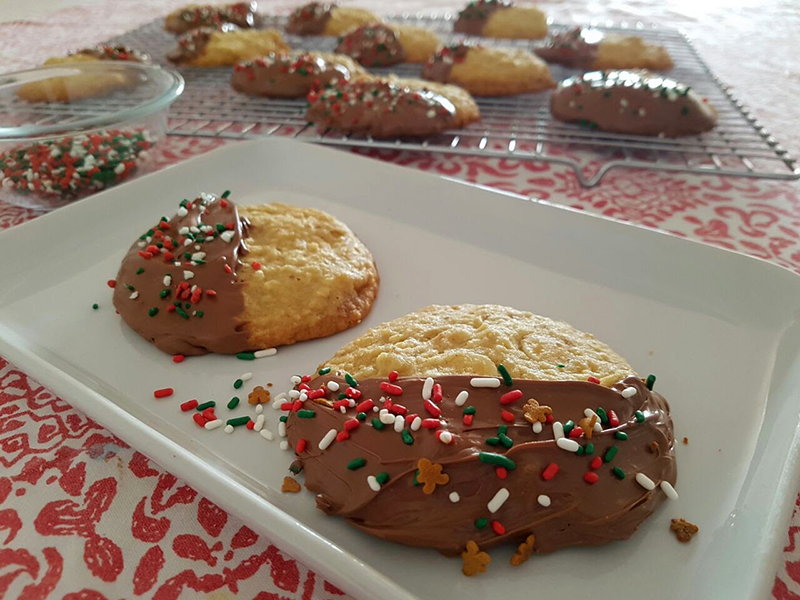 Cookies com gotas de chocolate branco e nozes cobertos com chocolate e vestidos para o Natal